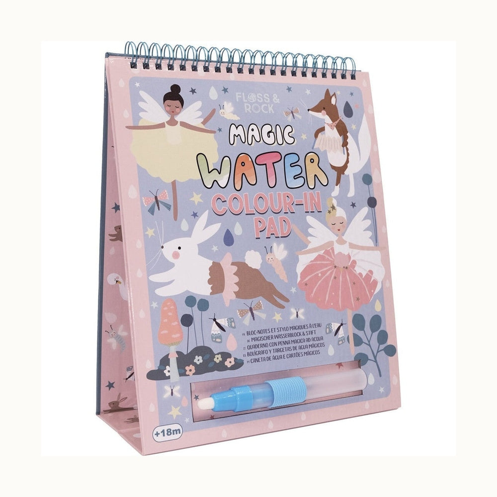 Floss & Rock spiral-bound Magic Water Colour-In Pad featuring a whimsical fairy-tale garden with winged fairies, a jumping white rabbit in a tutu, and a blue refillable water brush pen against a pastel pink background