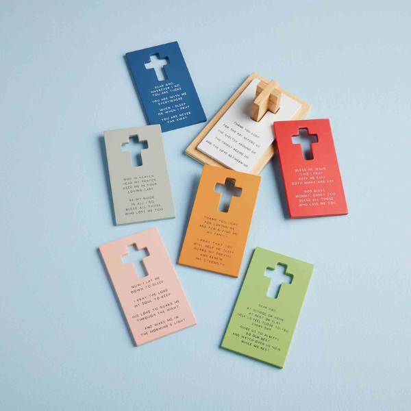 Painted wood prayer plaques featuring a collection of colorful religious tokens with cross-shaped cutouts and engraved inspirational verses displayed on a light blue background in shades of navy, coral, and lime green