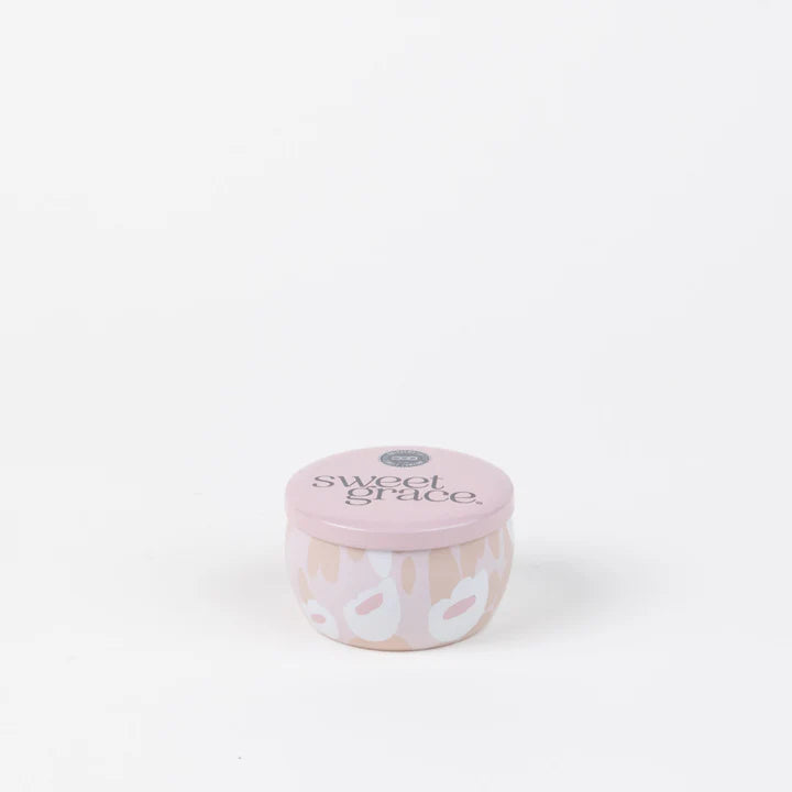 Scented metal candle tin by Bridgewater Candle Company featuring the Sweet Grace fragrance on a white background with a soft pink lid and an abstract peach and white floral pattern
