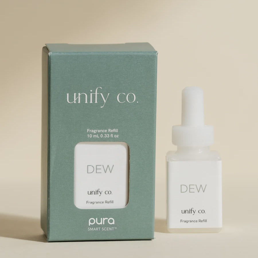 Commercial product photograph of unify co. DEW fragrance refills in a minimalist studio featuring a matte sage green box with a white Pura logo and a frosted white bottle with elegant serif typography