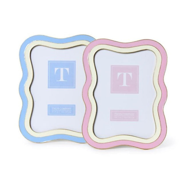 Enameled metal picture frames by Two's Company showcase wavy scalloped borders in sky blue and rose pink with metallic gold trim and distinctive T logo inserts on a white background