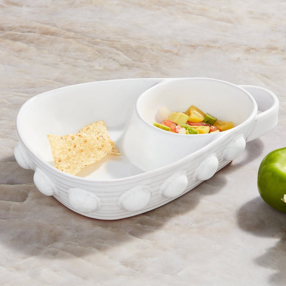 Ceramic stoneware serving bowl by Mud Pie on a marble countertop featuring a signature beaded exterior, a single golden tortilla chip, and a colorful medley of diced avocado and tomato salsa