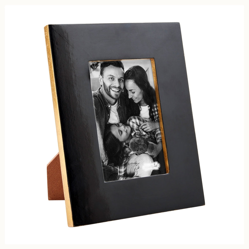 Enameled wood picture frame by Mud Pie featuring a black and white family portrait with hand-painted gold leaf edges and a glossy black finish on a brown easel stand