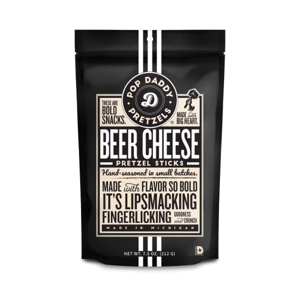 Product photography of Pop Daddy Beer Cheese Pretzel Sticks centered on a white background featuring a matte black pouch with three white vertical stripes, a cream label with bold vintage typography, and a circular logo highlighting its Michigan origin