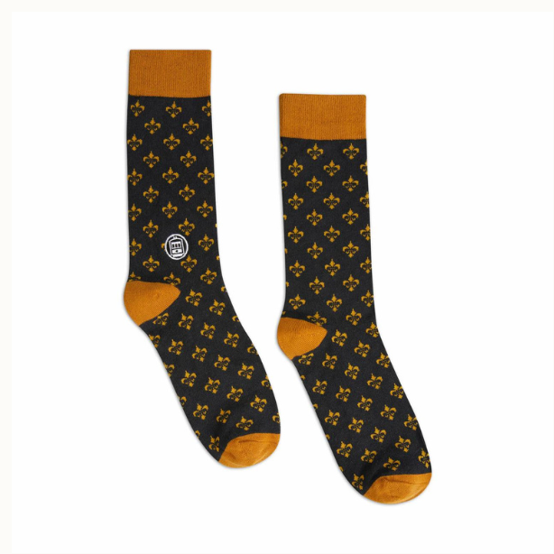 Fabric socks by Bonfolk featuring a New Orleans inspired design with a repeating golden fleur-de-lis pattern on a black base, a white streetcar logo, and vibrant mustard yellow cuffs, heels, and toes