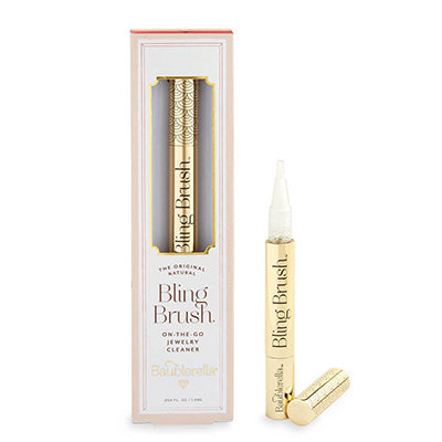 Product photograph by Baublerella of the Bling Brush jewelry cleaner set showcasing an ornate gold patterned applicator pen with a white brush tip and its elegant pink-trimmed retail packaging on a white background