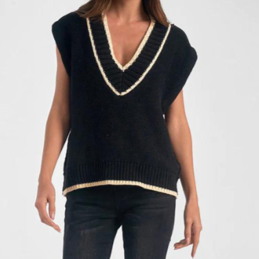 Photograph of a woman modeling a black sleeveless knit vest with a deep cream-trimmed V-neck and a matching ribbed hem against a plain white studio background