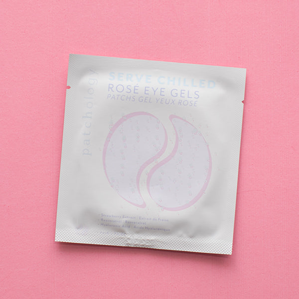 Product photograph of a Patchology Rosé Eye Gels sachet centered on a textured pink background featuring two light pink crescent-shaped gel illustrations and pale blue Serve Chilled branding above a white ingredient list at the bottom