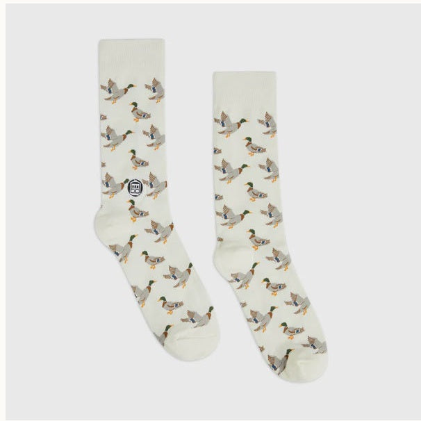 Knitted cotton socks by London Sock Co featuring a repeated pattern of mallard ducks with vibrant green heads and orange feet displayed on a cream fabric against a neutral background