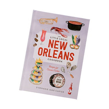 Stephanie Jane Carter’s illustrated cookbook cover for The Little Local New Orleans Cookbook features a Preservation Hall Jazz Band drum icon, a colorful tiered king cake, and a bright red crawfish against a pale lavender backdrop