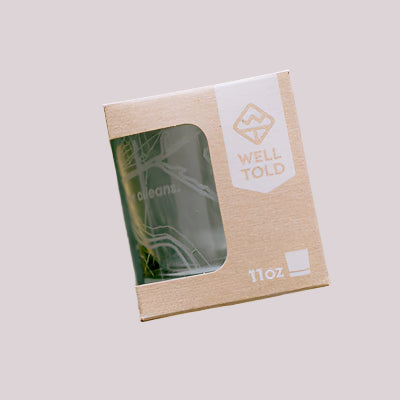 Etched glass by Well Told featuring a map of New Orleans with the Mississippi River curve and street lines visible inside a kraft paper box with a white logo and 11oz capacity mark